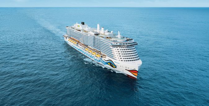 Die AIDAcosma fährt über das weite Meer, mit klar sichtbaren Außendecks und markantem AIDA-Bugdesign