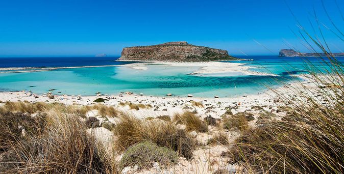 Blick auf die Lagune von Balos auf Kreta mit türkisfarbenem Wasser, Sandstrand und felsigen Inseln im Hintergrund