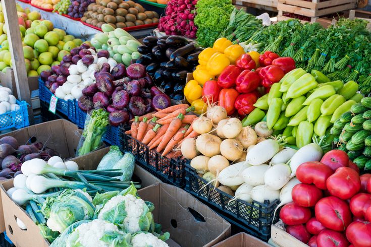 Buntes Sortiment aus frischem Gemüse wie Paprika, Karotten, Tomaten und Kohl auf einem Marktstand