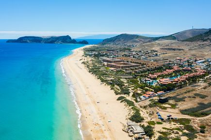 Luftaufnahme des Sandstrands von Porto Santo in Portugal mit türkisblauem Meer, heller Küstenlinie, Hotelanlagen und der weitläufigen Landschaft der Insel
