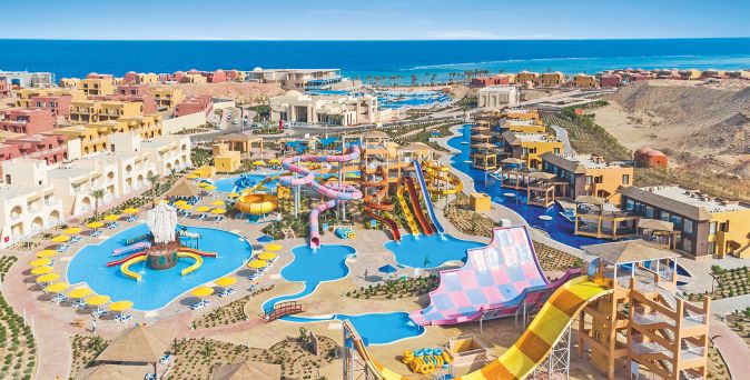 Blick auf das Pickalbatros Villaggio Resort Portofino mit mehreren Wasserrutschen, Pools und angrenzenden Hotelgebäuden am Meer.