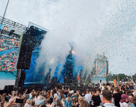 Große Festivalbühne mit Konfettiregen vor jubelndem Publikum beim Katta und seine Freunde Kinderfestival, farbenfrohe Bühnenshow als Familienevent