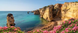 Praia Dona Ana bei Lagos an der Algarve in Portugal mit goldfarbenen Felsklippen, türkisfarbenem Meer und geschützter Badebucht
