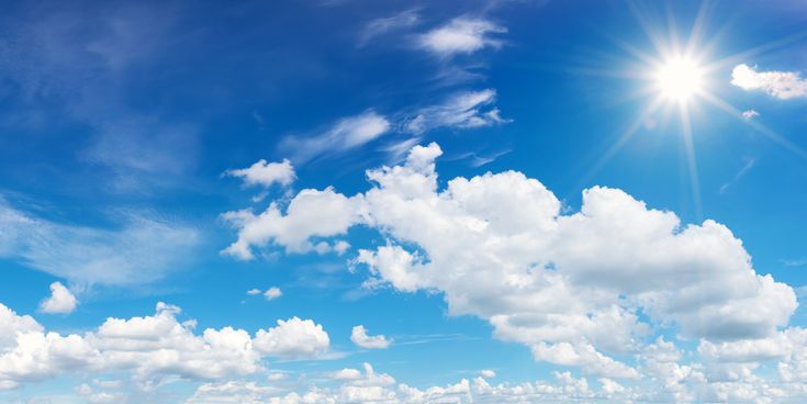 Blauer Himmel mit weißen Wolken und strahlender Sonne