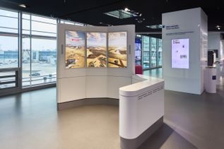 Besucherzentrum am Flughafen Frankfurt mit interaktiven Informationsstationen, digitalen Displays und Blick auf das Vorfeld durch die Terminalverglasung