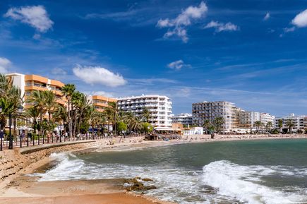 Promenade von Santa Eulalia auf Ibiza mit Hotels, Palmen und Blick auf den Strand und das Meer