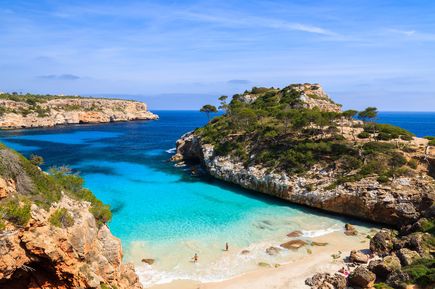 Idyllische Bucht Cala des Moro auf Mallorca mit smaragdgrünem Wasser, Sandstrand und umrahmenden Felsen