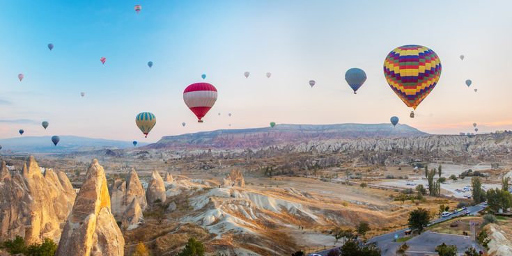Bunte Heißluftballons über der Felslandschaft Kappadokiens in der Türkei bei Sonnenaufgang