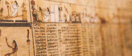 Detailaufnahme eines antiken ägyptischen Papyrus mit Hieroglyphen und Abbildungen von Figuren und Szenen
