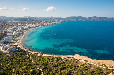 Luftaufnahme von Cala Millor auf Mallorca mit weitem Sandstrand, türkisblauem Meer und Hotelanlagen entlang der Küste